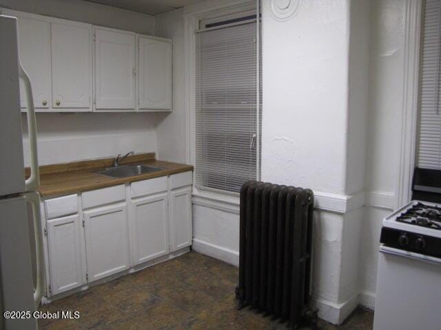 37-39 N Manning Blvd, Albany, NY 12206 - kitchen with a sink, range with gas stovetop, freestanding refrigerator, radiator, and white cabinets