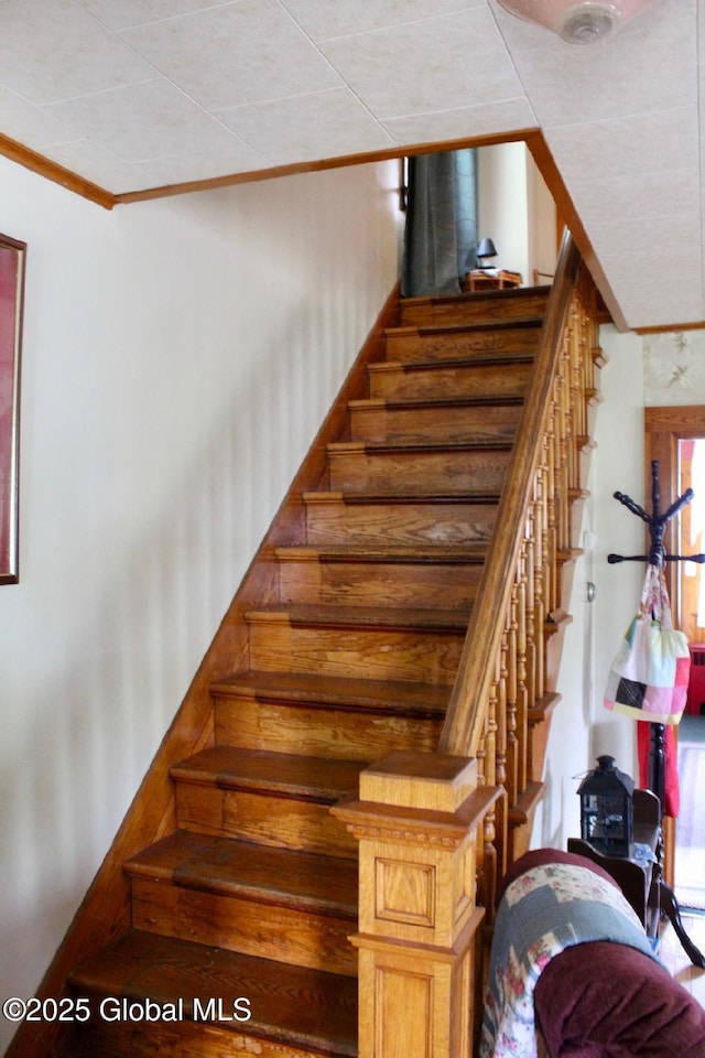 stairway featuring ornamental molding