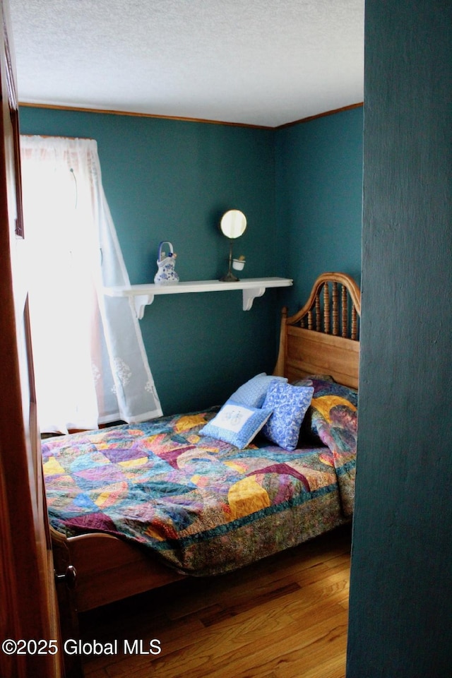 bedroom with wood-type flooring and a textured ceiling