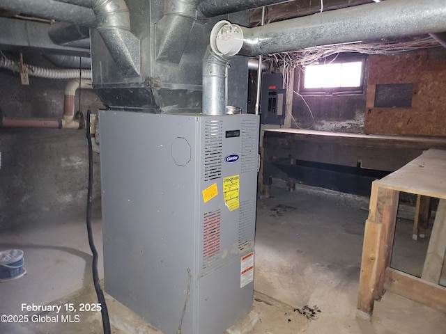 utility room with heating unit and electric panel