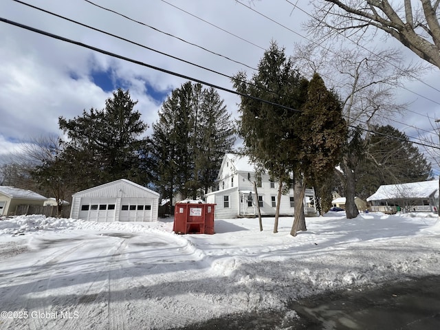 yard layered in snow with an outbuilding and a garage