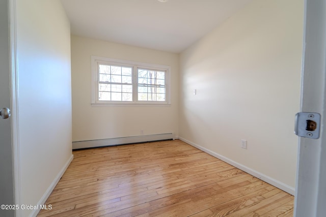 unfurnished room with light wood finished floors, baseboard heating, and baseboards