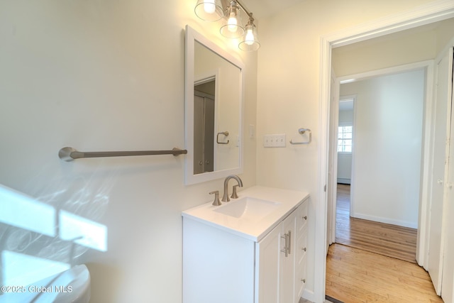 bathroom with vanity, baseboards, and wood finished floors