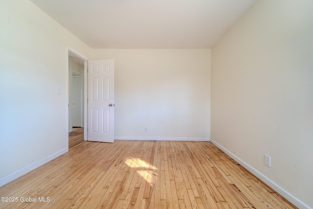 unfurnished room featuring baseboards and hardwood / wood-style flooring