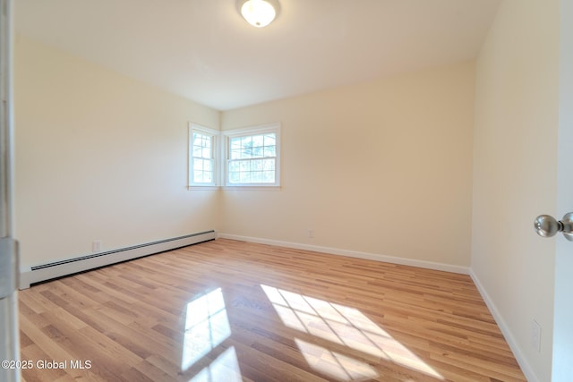 unfurnished room featuring wood finished floors, baseboards, and baseboard heating