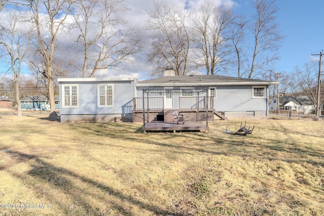 rear view of house featuring a deck, a yard, fence, and a chimney