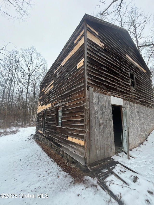 snow covered property with an outbuilding