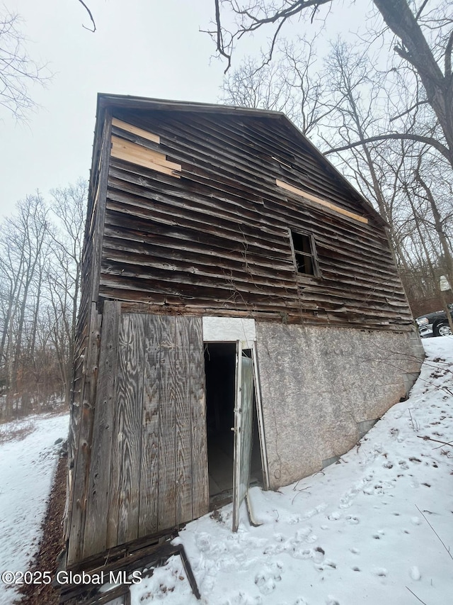 view of snowy exterior with an outbuilding