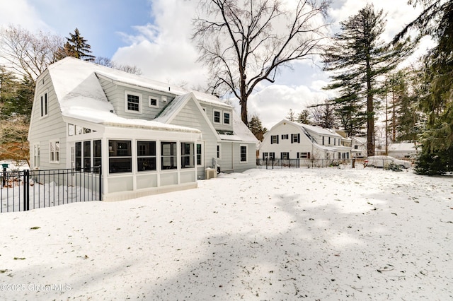 snow covered property with a sunroom