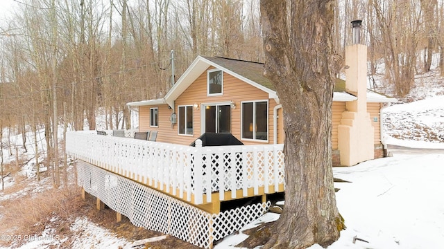 snow covered property with a deck