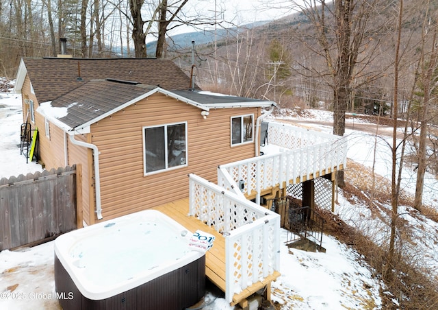 exterior space featuring a deck with mountain view and a hot tub