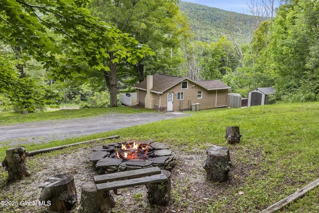 117 Kleis Rd, Fleischmanns, NY 12430 - view of grassy yard featuring an outdoor fire pit, a storage unit, a mountain view, and a wooded view