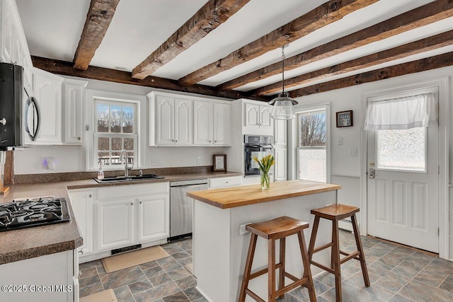 kitchen featuring butcher block counters, white cabinetry, a sink, and black appliances