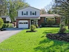 tri-level home featuring a front lawn and a garage