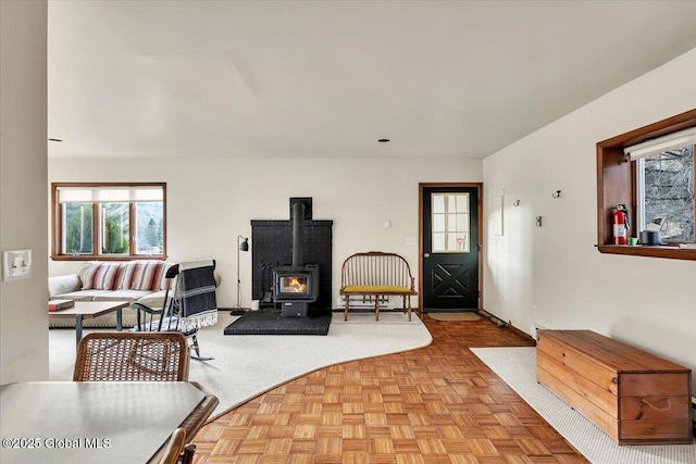 living area with a wood stove and a healthy amount of sunlight