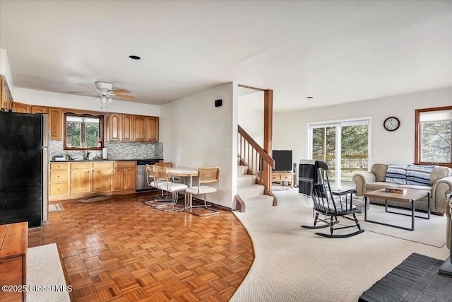 kitchen featuring stainless steel appliances, open floor plan, a sink, and tasteful backsplash