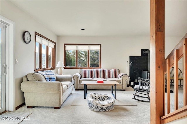 living room featuring carpet floors and a wood stove