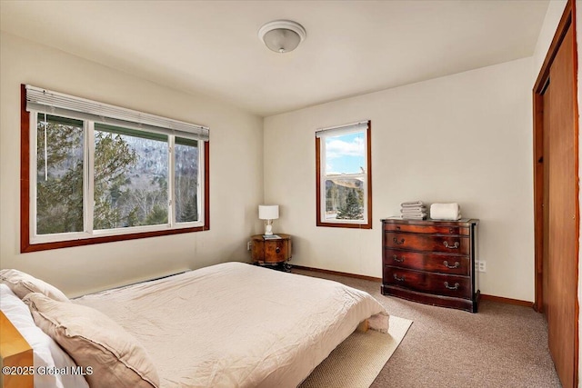 bedroom with light colored carpet and baseboards