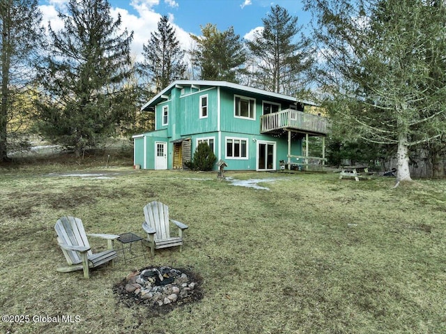 rear view of house featuring a yard, an outdoor fire pit, and a wooden deck