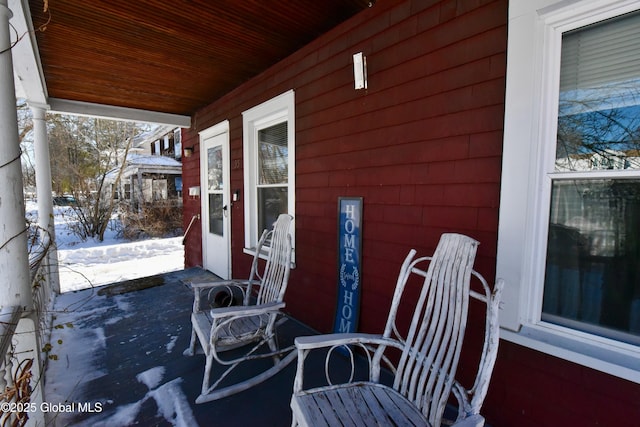 snow covered patio featuring a porch