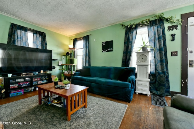 living room with dark hardwood / wood-style floors, a textured ceiling, and crown molding