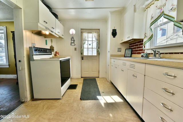 kitchen with white cabinets, white electric stove, hanging light fixtures, and sink