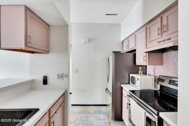 kitchen featuring appliances with stainless steel finishes, decorative backsplash, and light brown cabinets