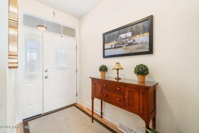 foyer entrance with light wood-type flooring and visible vents