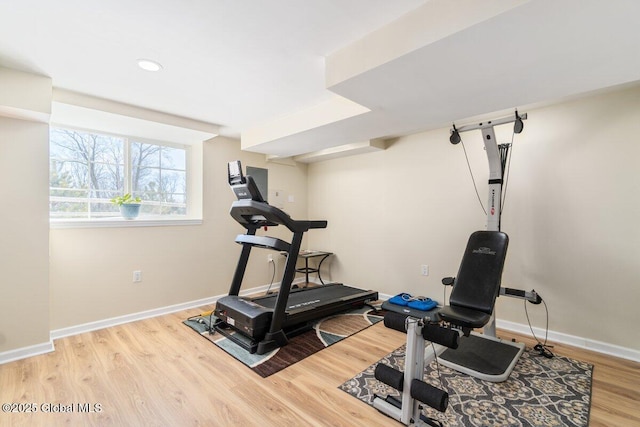 exercise room with baseboards, wood finished floors, and recessed lighting