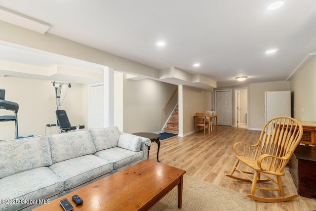 living area featuring light wood-style flooring, stairs, baseboards, and recessed lighting