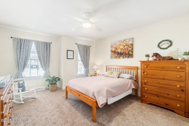 carpeted bedroom with ceiling fan and baseboards