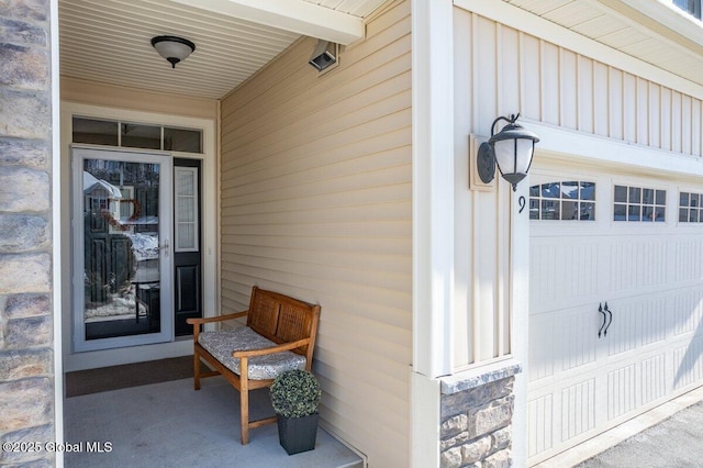 property entrance with an attached garage and board and batten siding