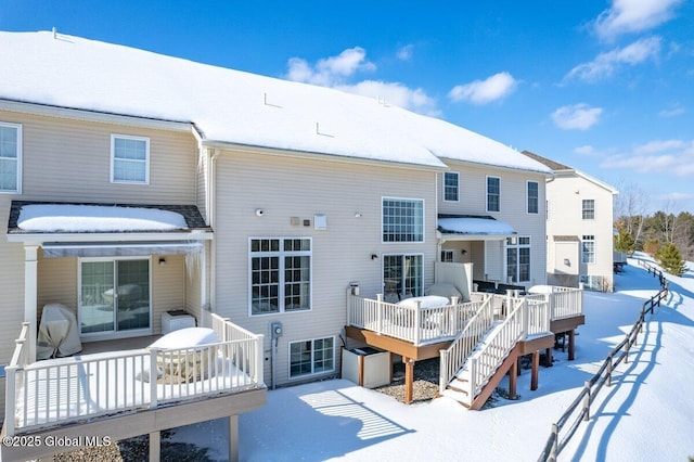 snow covered house with a wooden deck