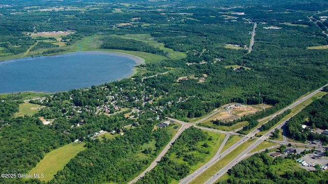 drone / aerial view featuring a water view and a wooded view