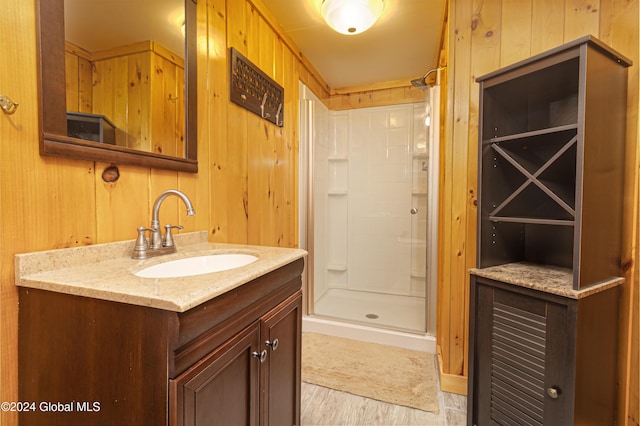 bathroom featuring wooden walls, an enclosed shower, and vanity