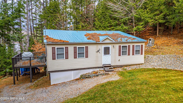 view of front of home with a deck and a front yard