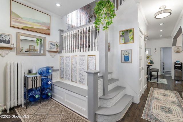 stairs with ornamental molding, recessed lighting, wood finished floors, and radiator