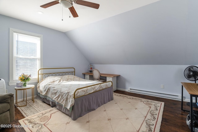 bedroom with a baseboard heating unit, lofted ceiling, and baseboards