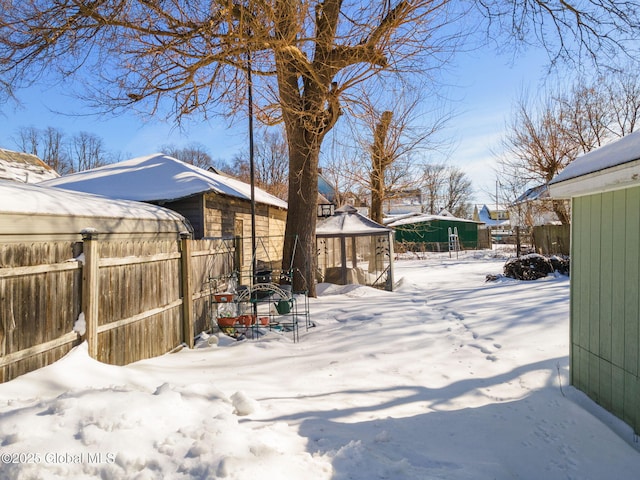 yard layered in snow featuring fence