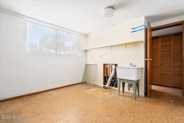 below grade area with tile patterned floors and concrete block wall