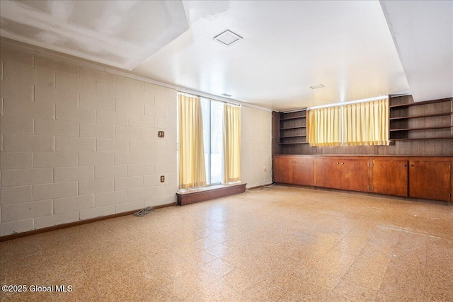 empty room featuring light floors and concrete block wall