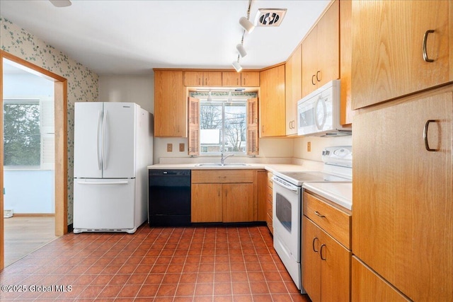 kitchen featuring white appliances, visible vents, a sink, tile patterned flooring, and light countertops