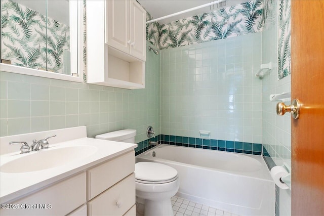 bathroom with tub / shower combination, tile walls, toilet, tile patterned floors, and vanity