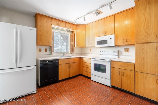 kitchen featuring visible vents, a sink, white appliances, rail lighting, and light countertops