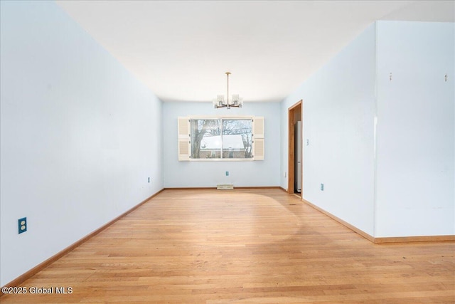 interior space with light wood-type flooring, baseboards, and a notable chandelier