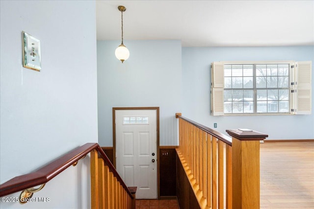 stairs with a wealth of natural light and wood finished floors