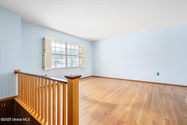 empty room featuring baseboards and wood-type flooring