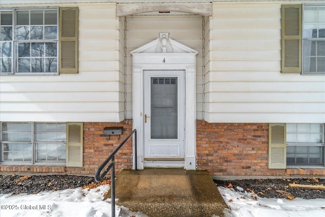 entrance to property featuring brick siding