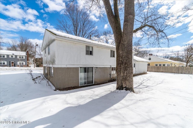 snow covered property featuring fence