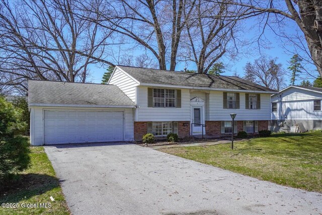 4 Iroquois Dr, Saratoga Springs, NY 12866 - bi-level home with aphalt driveway, a front lawn, brick siding, and an attached garage